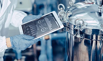 Person holding tablet near equipment